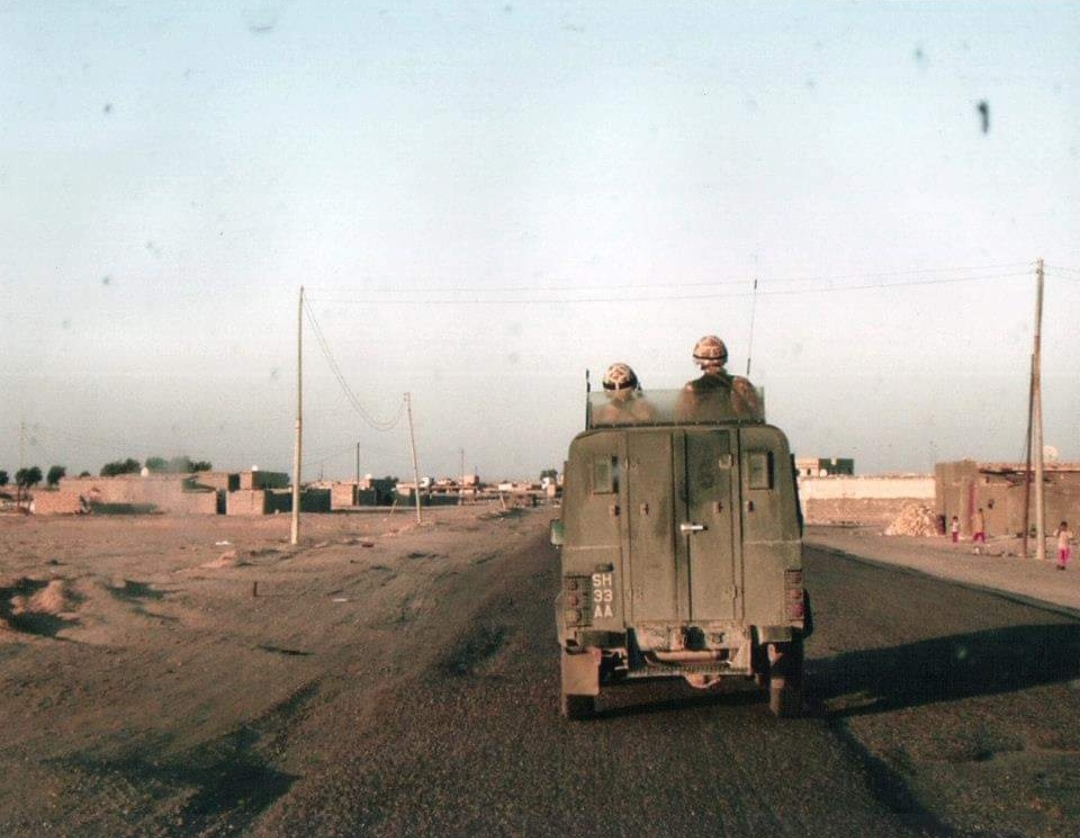 Image shows RAF personnel driving an open top truck in Iraq. 